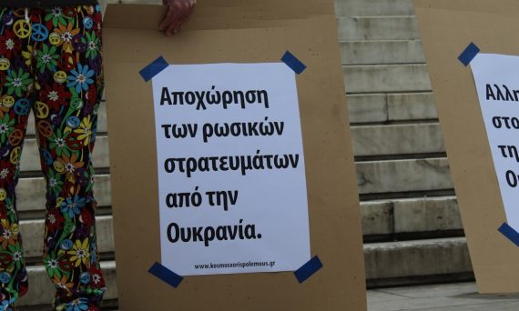 a couple of people standing next to each other holding signs